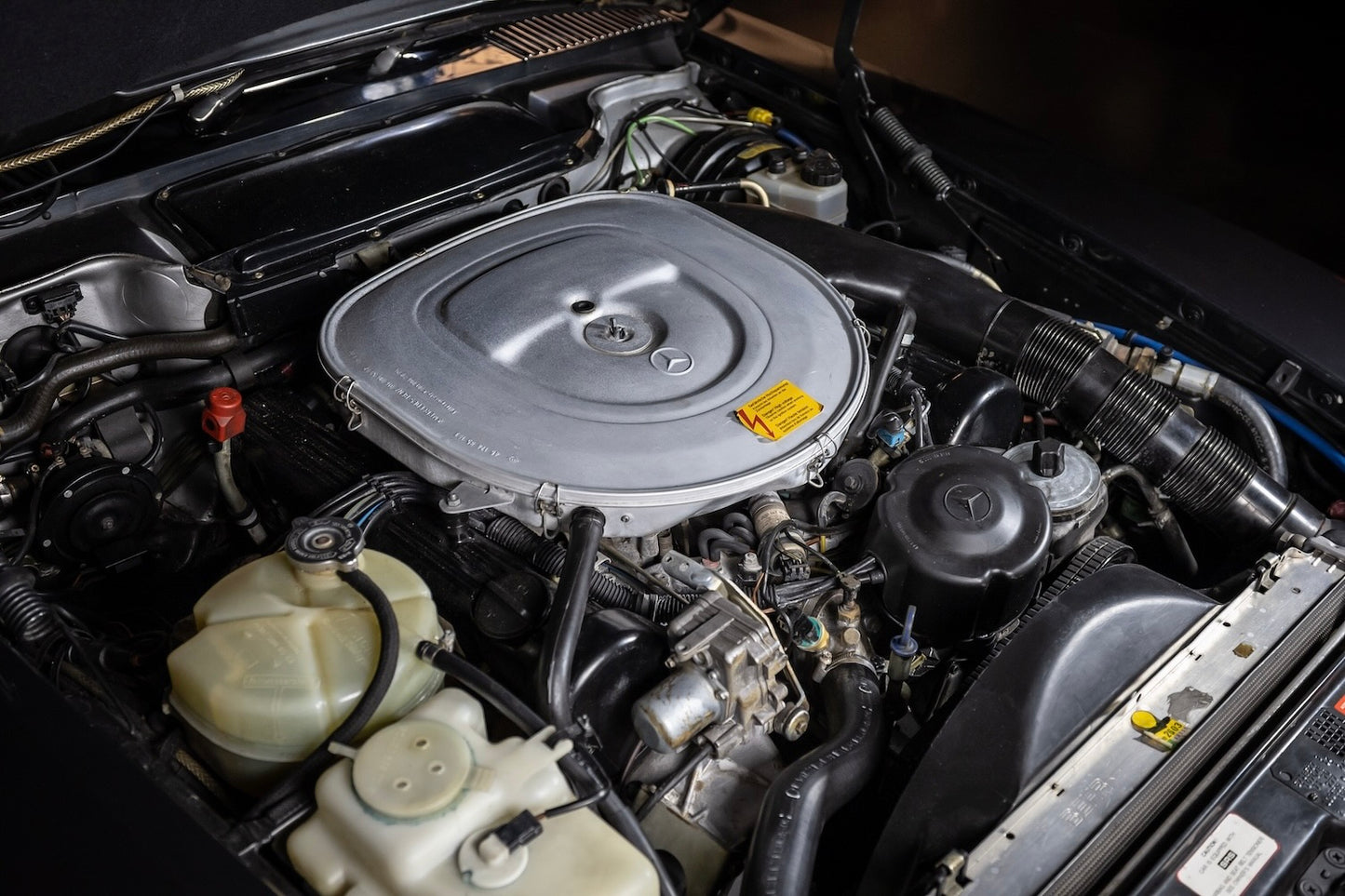 Car engine compartment with various components visible