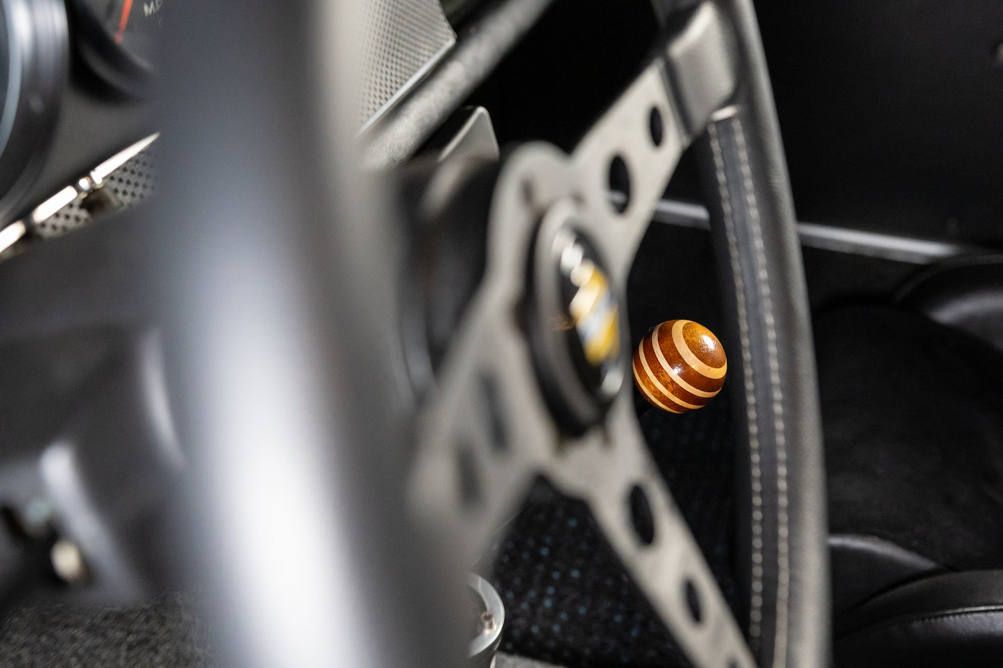 Close-up of a car's gear shift lever with a wooden knob
