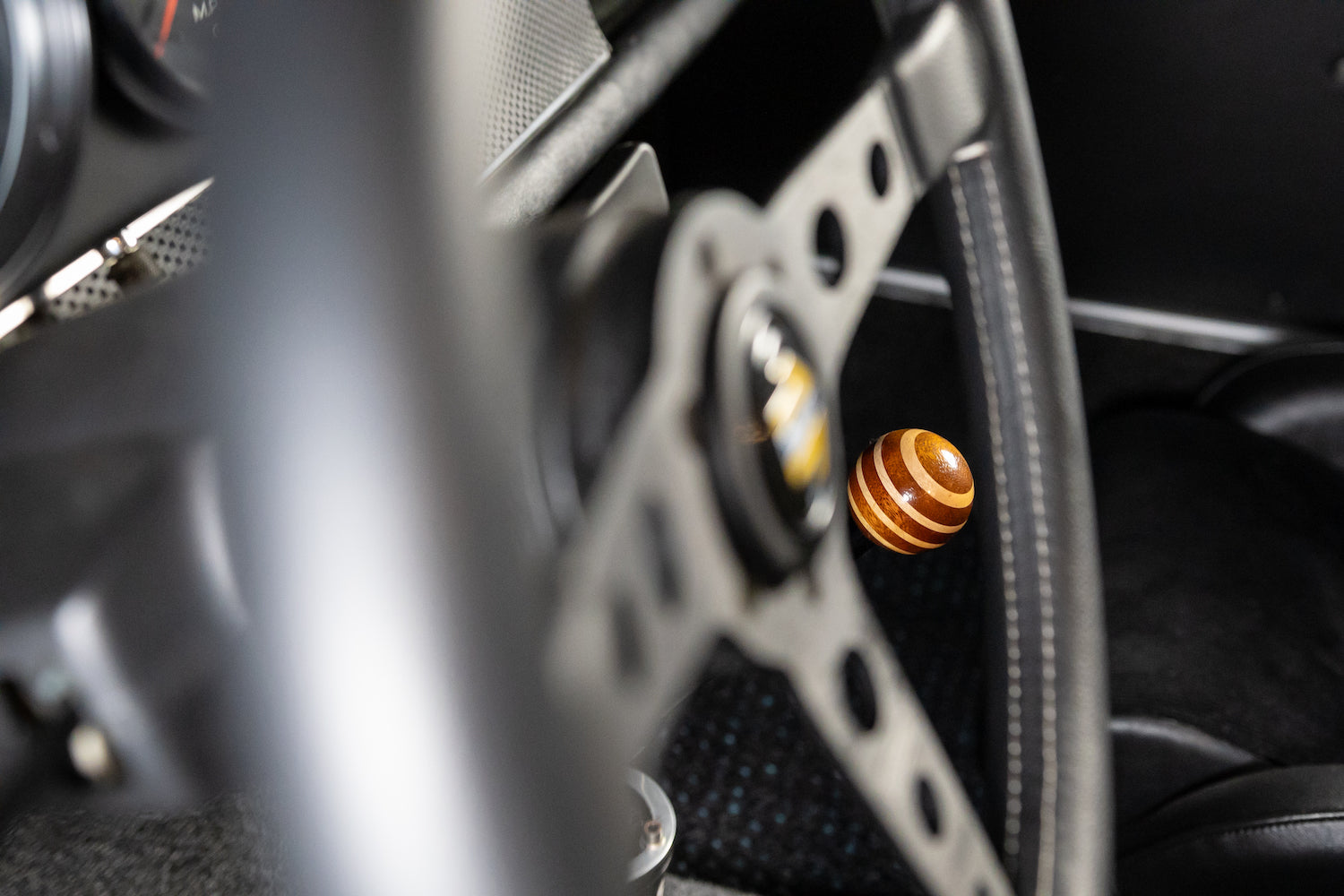 Close-up of a car's gear shift lever with a wooden knob