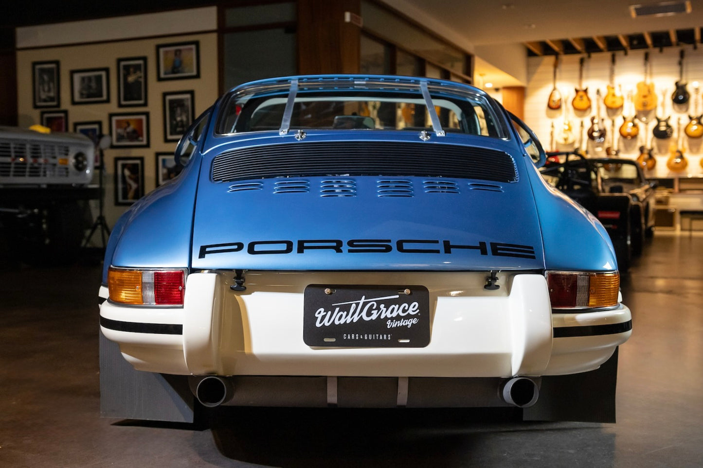 Blue Porsche car with a visible license plate in an indoor setting