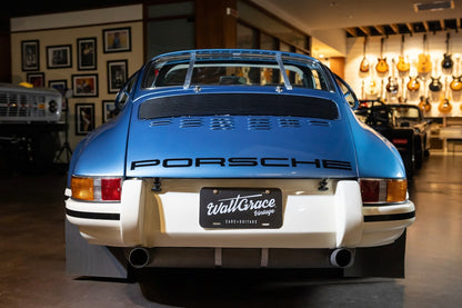 Blue Porsche car with a visible license plate in an indoor setting