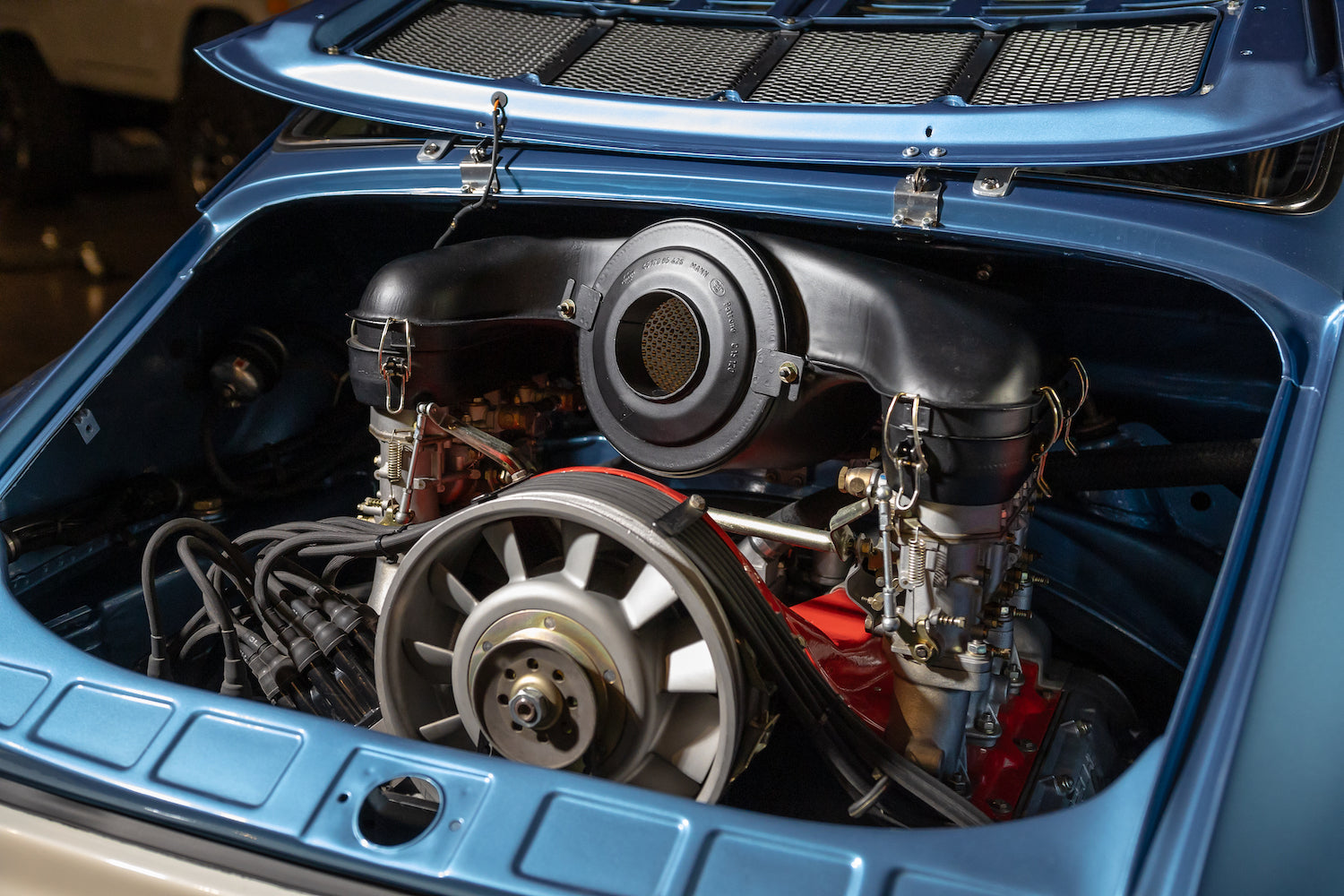 Engine compartment of a blue car with visible components
