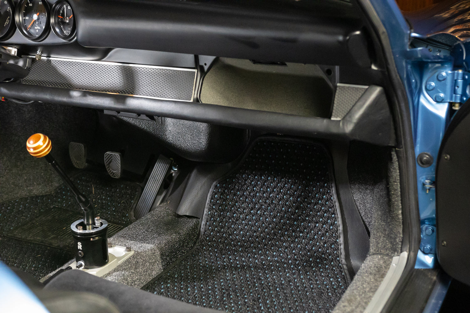 Close-up of a car's interior with a focus on the gear shift and surrounding area.