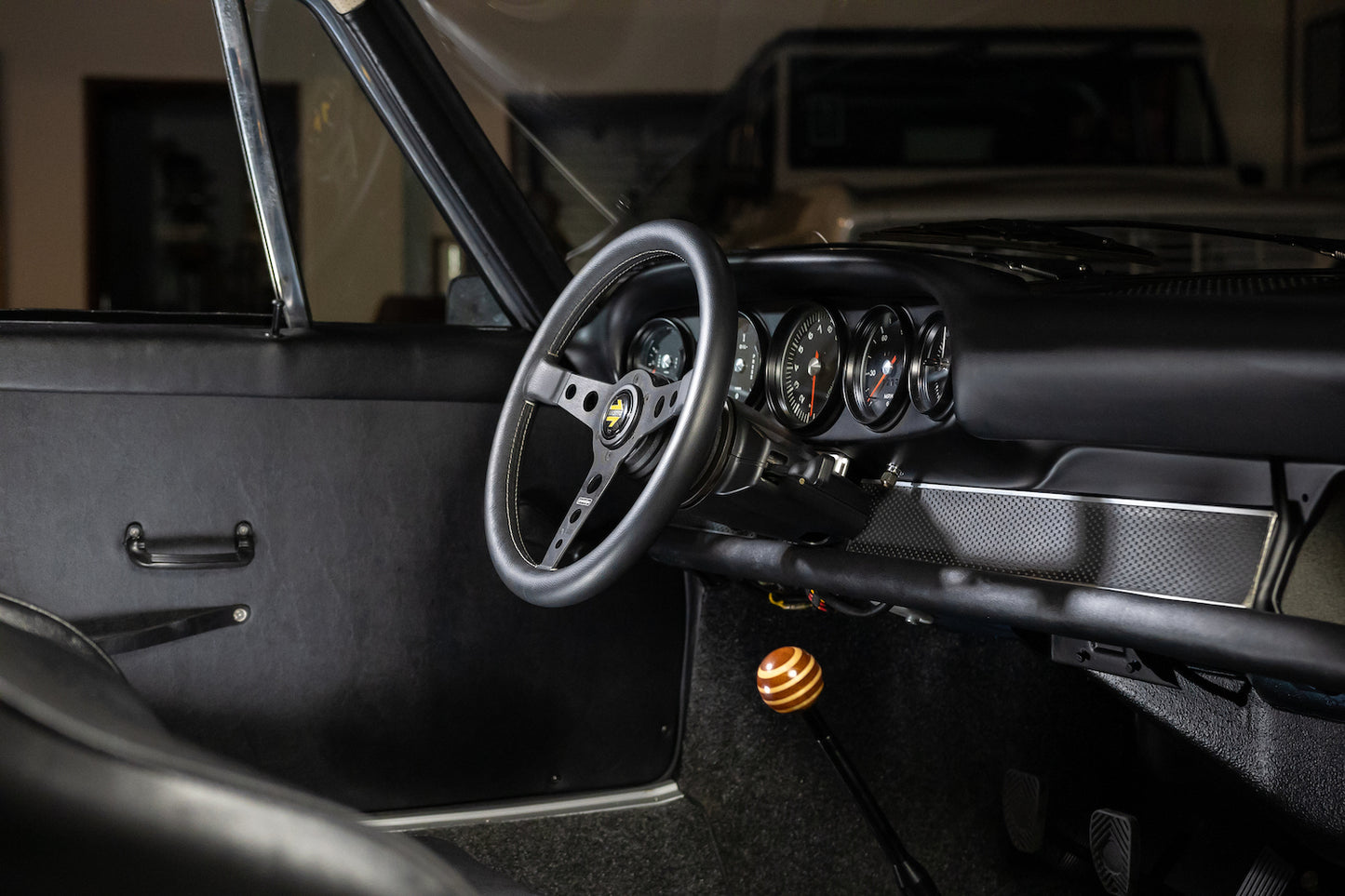 Close-up of a car's steering wheel and dashboard with a focus on the gear shift.
