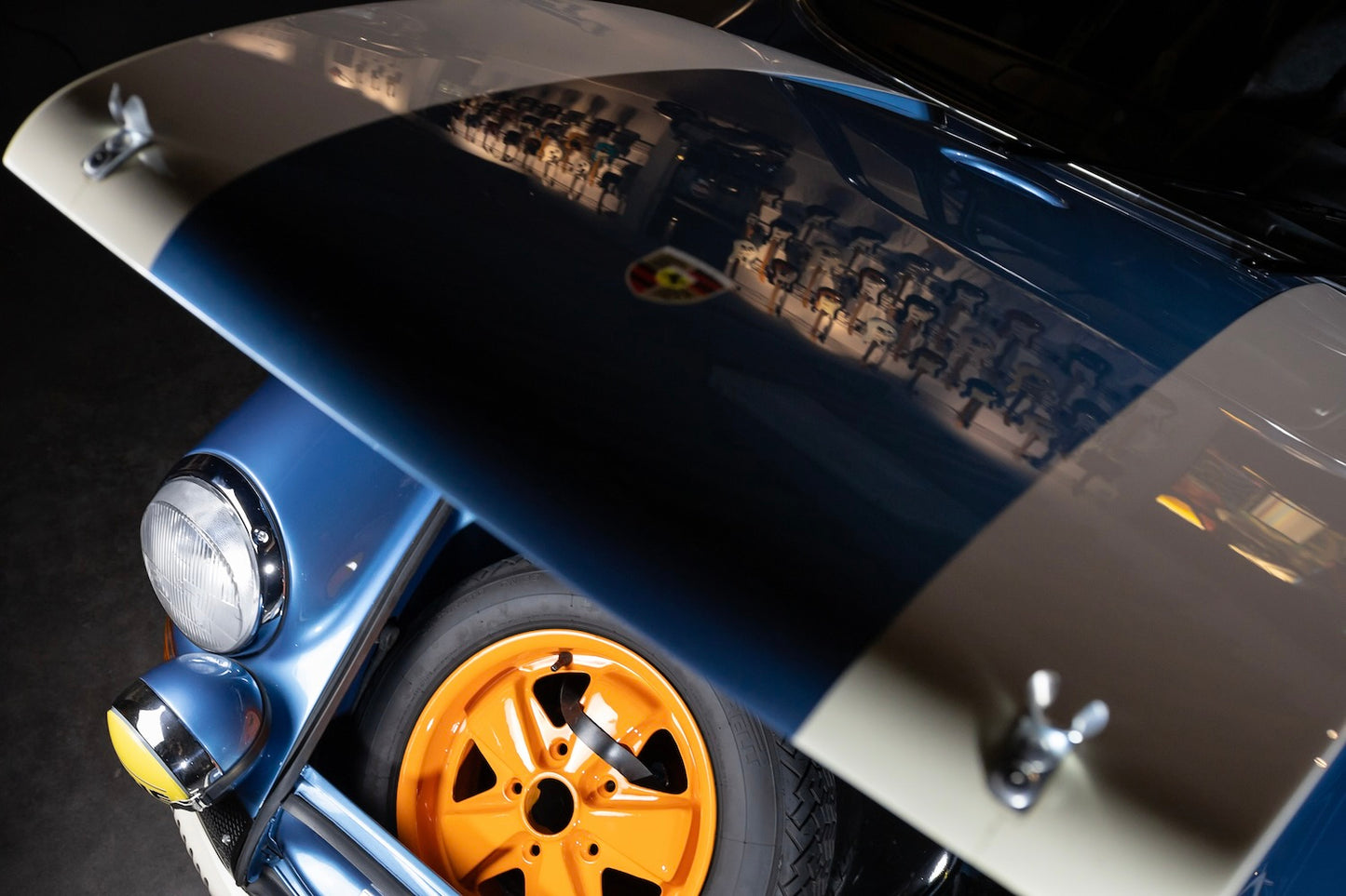 Close-up of a car's front wheel and fender with a blue and silver color scheme.
