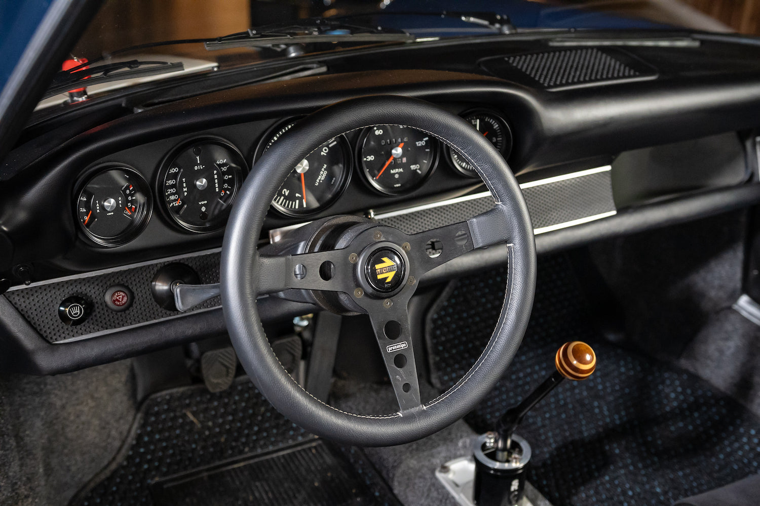 Close-up of a car's steering wheel and dashboard with visible brand logo.