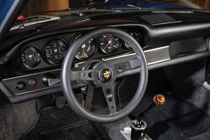Close-up of a car's steering wheel and dashboard with visible brand logo.
