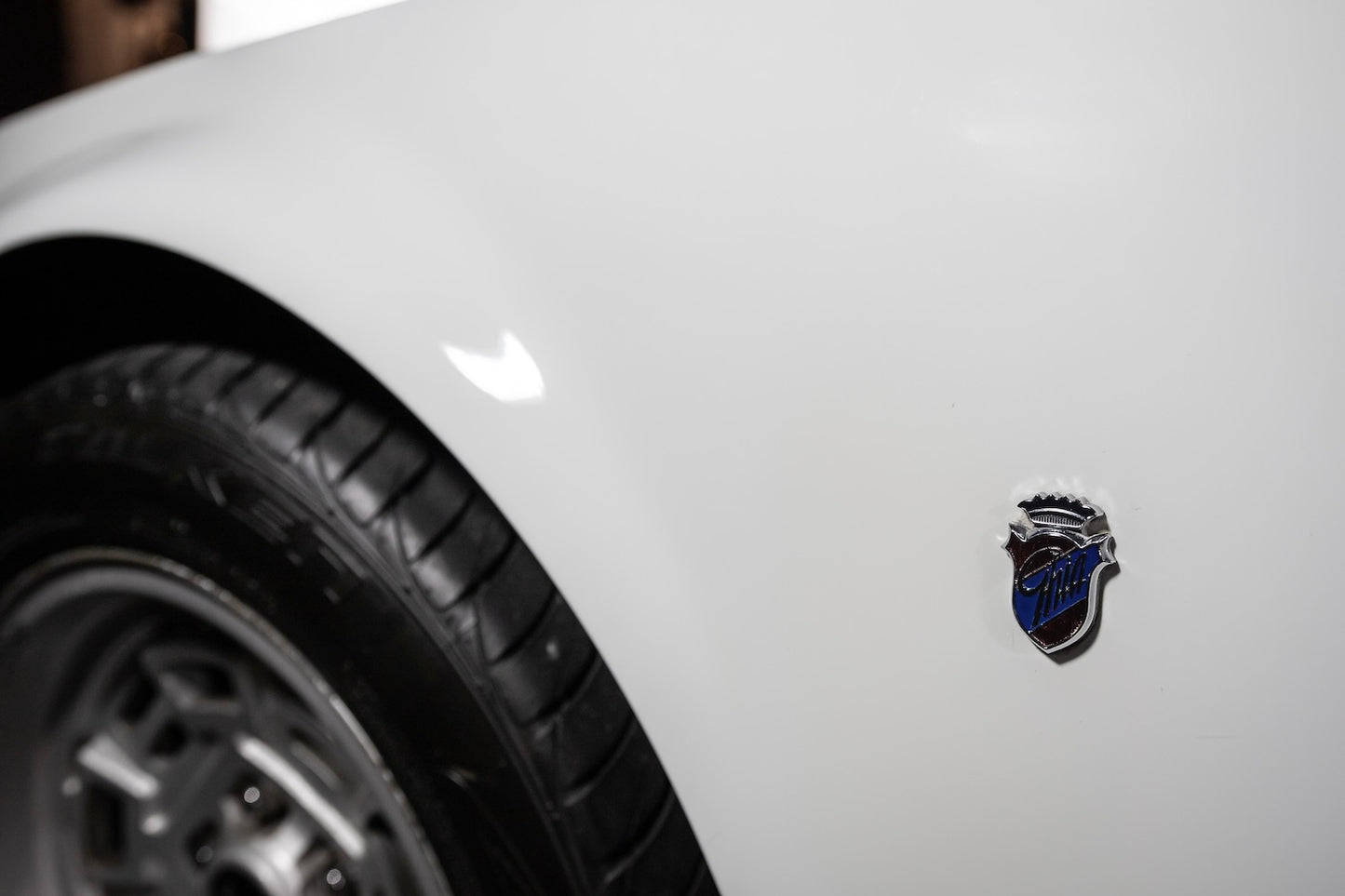 Close-up of a car emblem on a white vehicle