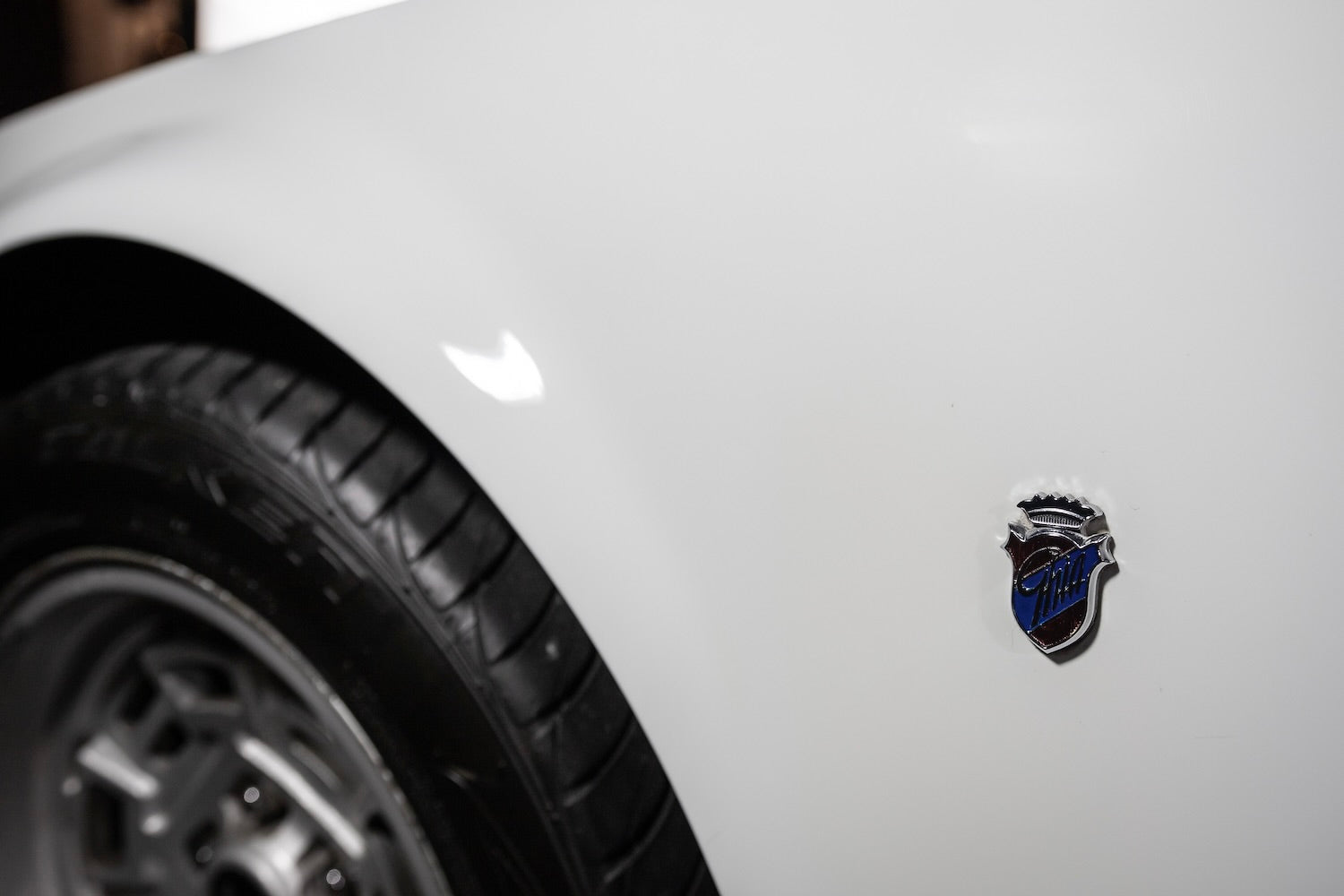 Close-up of a car emblem on a white vehicle