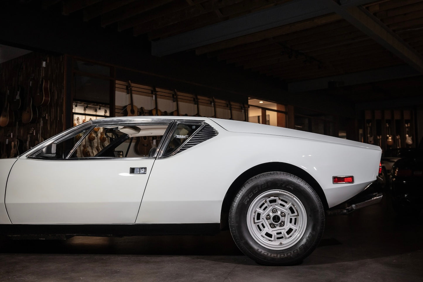 White vintage car parked inside a dark garage