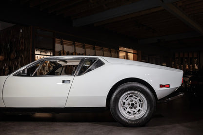 White vintage car parked inside a dark garage