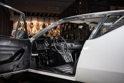 Car interior with open door in a room with guitars on the wall