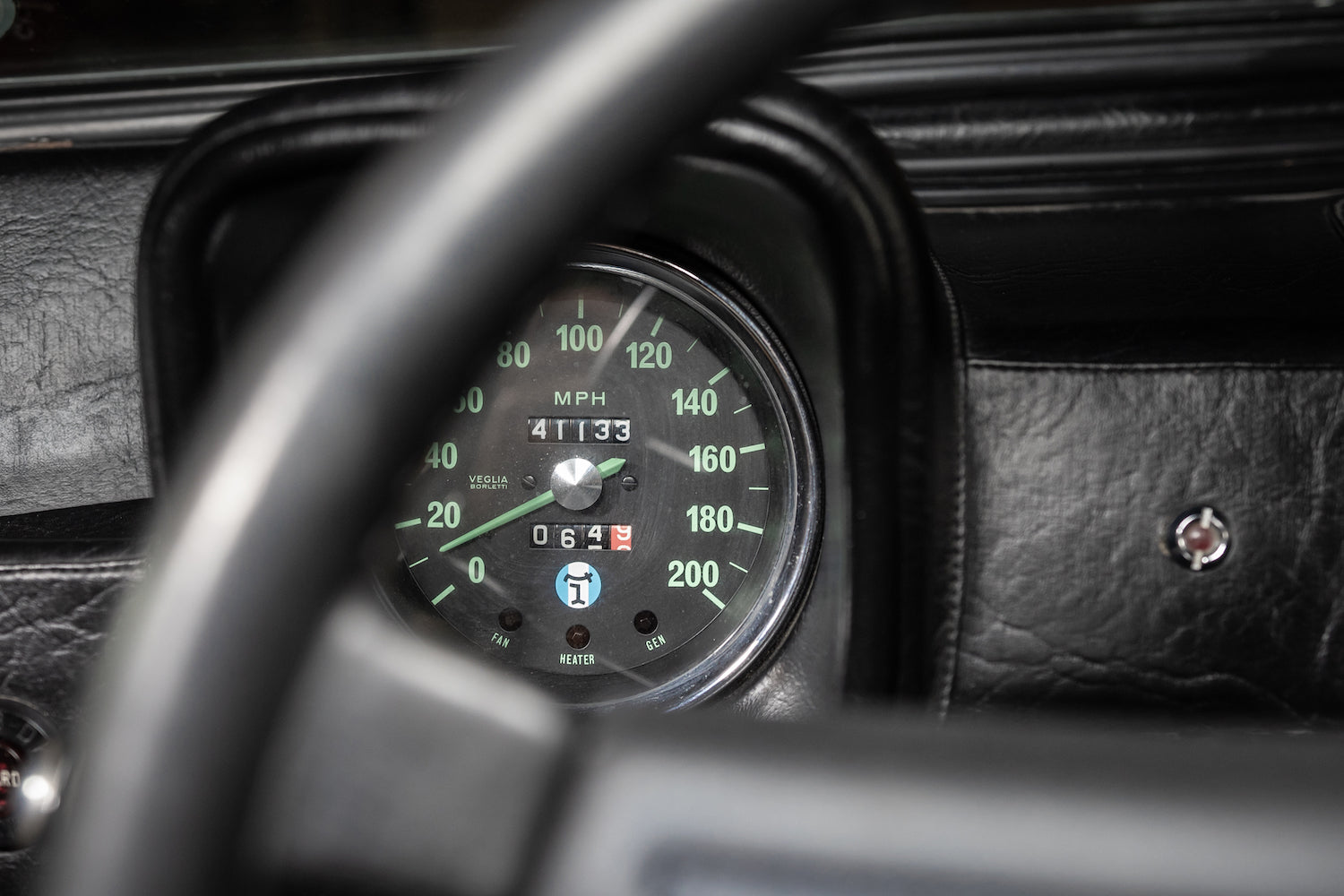 Close-up of a car dashboard with a speedometer and tachometer.