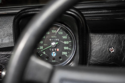 Close-up of a car dashboard with a speedometer and tachometer.