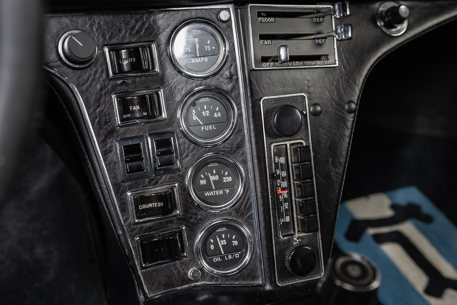 Close-up of a vintage car dashboard with gauges and controls.