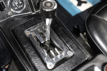 Close-up of a car gear shift lever in a vehicle interior.