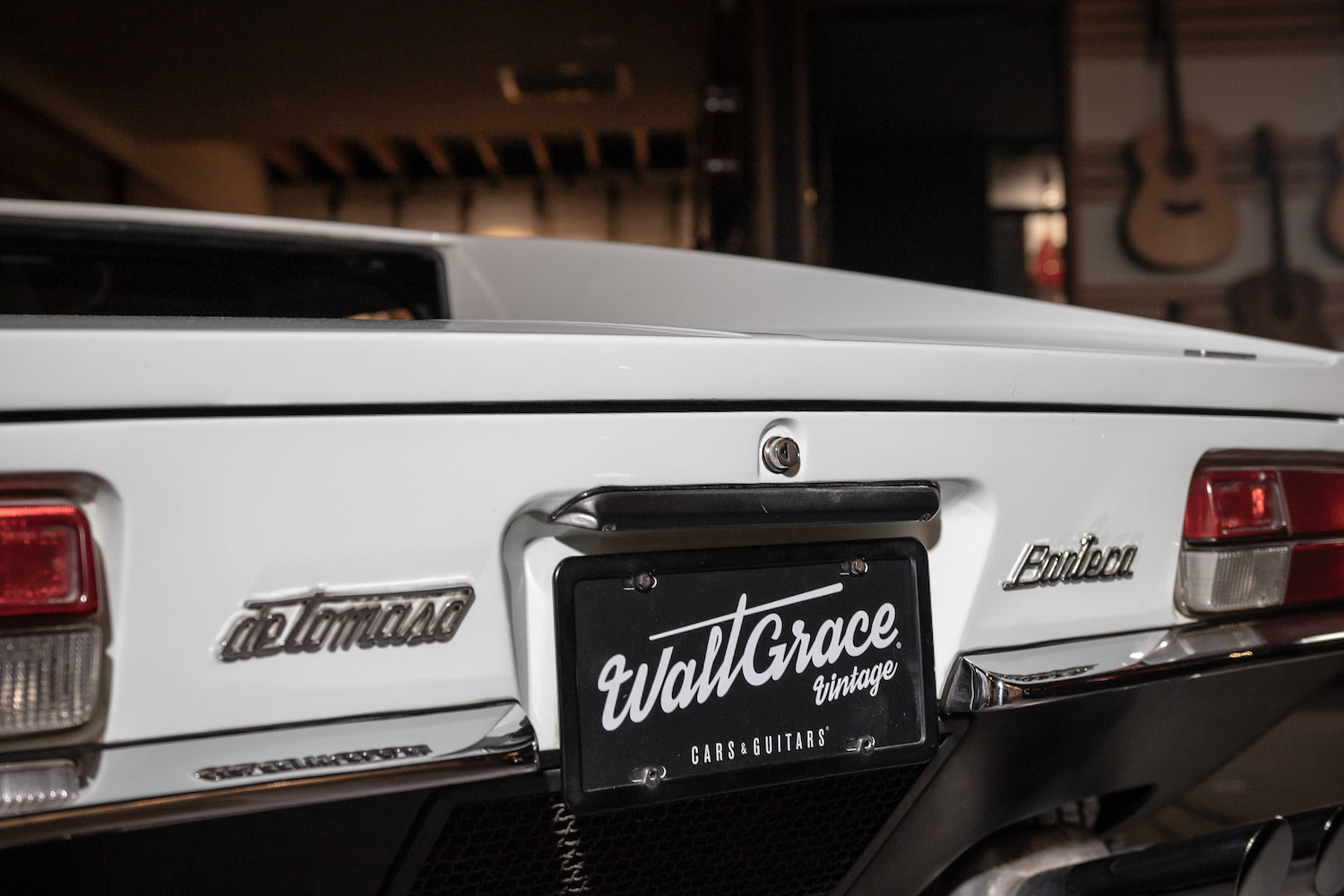 White car with 'Wall Grace' license plate in a garage setting
