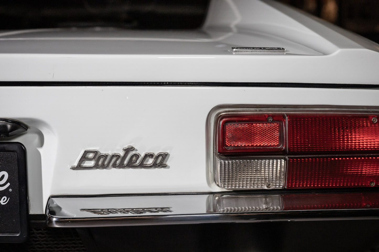 Close-up of a white car with 'Pantera' branding on the trunk.