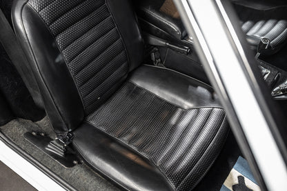 Close-up of a car seat with a textured pattern, showing the interior design and materials.
