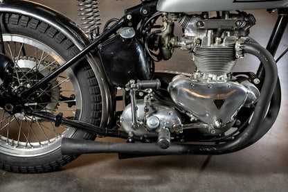 Close-up of a motorcycle engine and wheel on a gray background