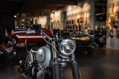 Close-up of a motorcycle in a showroom with other vehicles in the background