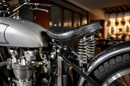 Close-up of a motorcycle's engine and seat in an indoor setting