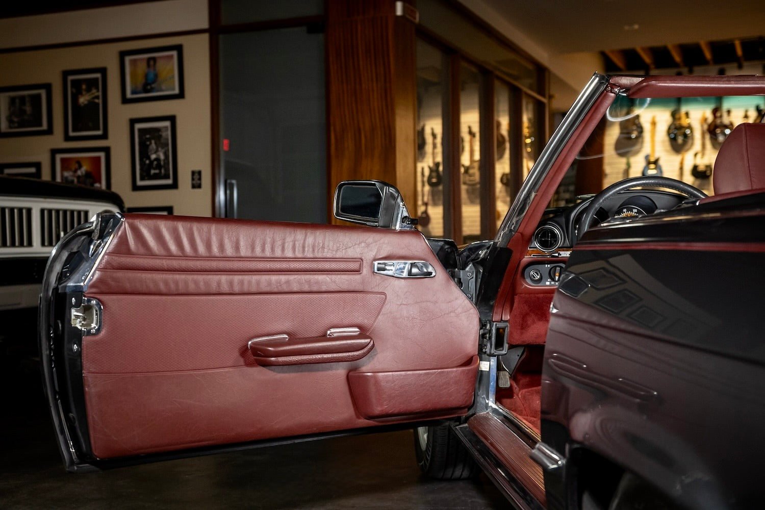 Close-up of a vintage car interior with open door in a showroom setting.