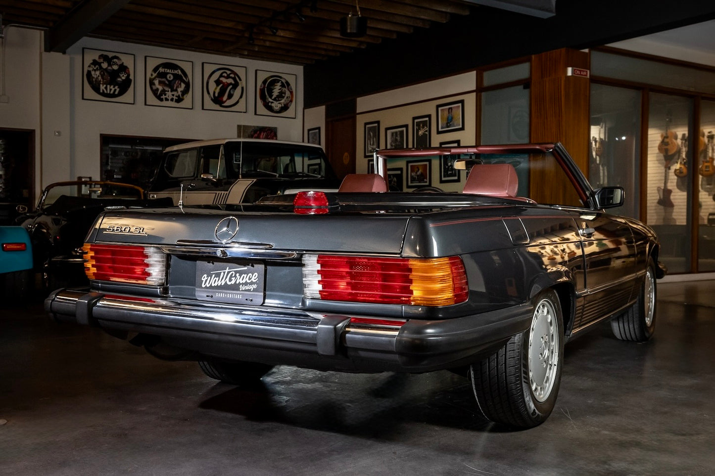 Vintage car in a showroom setting with other vehicles and decor in the background