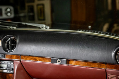 Close-up of a car's interior dashboard with leather and wood trim.