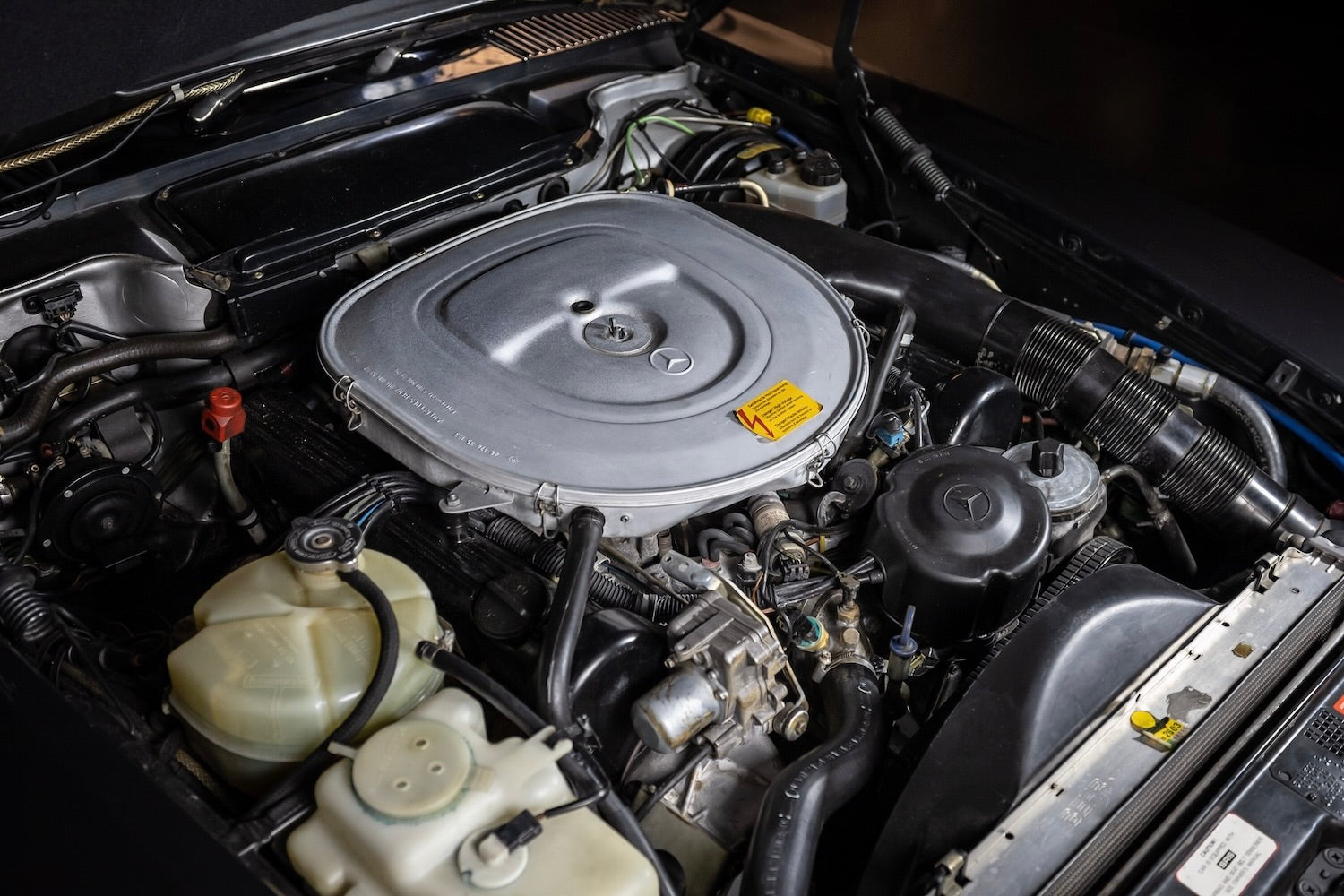 Car engine compartment with various components visible