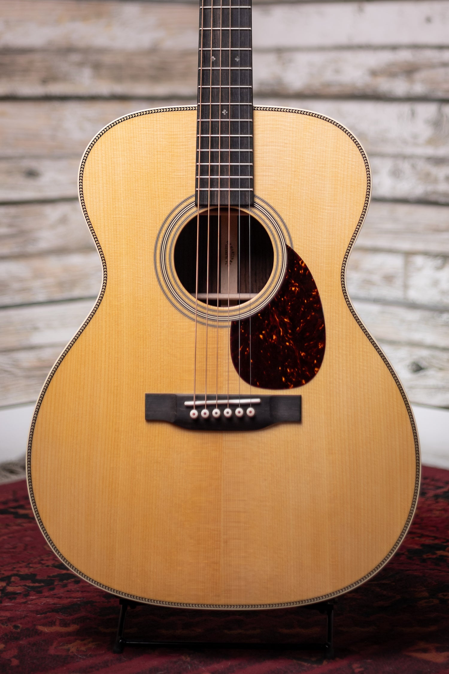 Acoustic guitar with a wooden finish on a wooden background