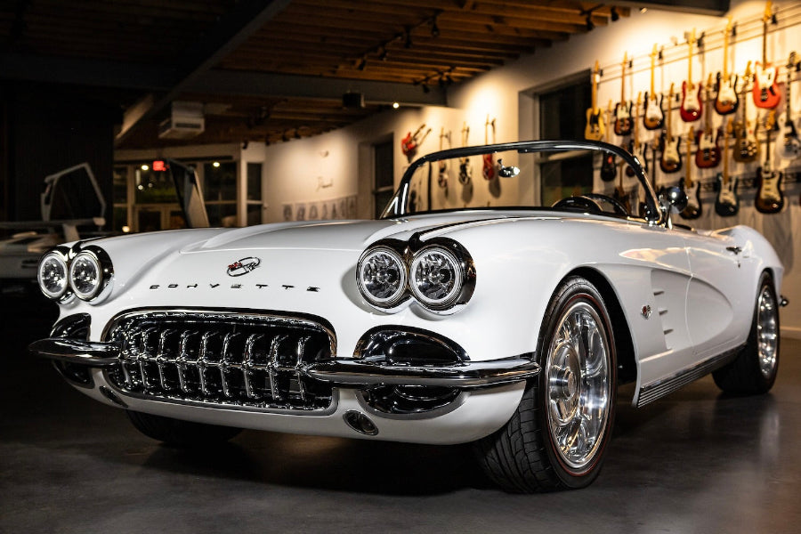 A white 1962 Chevrolet Corvette 'Restomod' with a 1958 Corvette chrome front grille, displayed indoors.