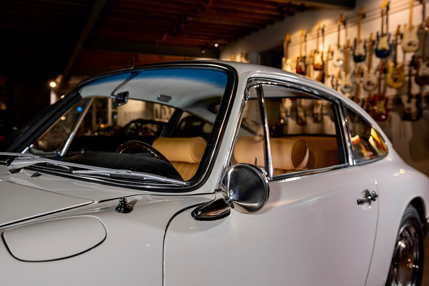 Vintage car in a showroom with guitar wall in the background