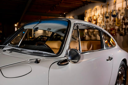 Vintage car in a showroom with guitar wall in the background