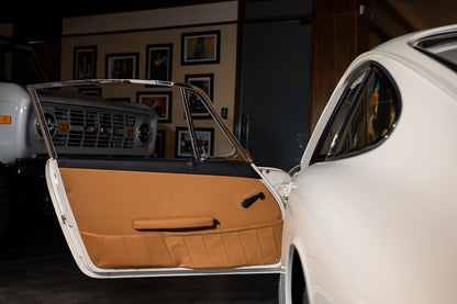 Car door open with beige interior in a garage setting