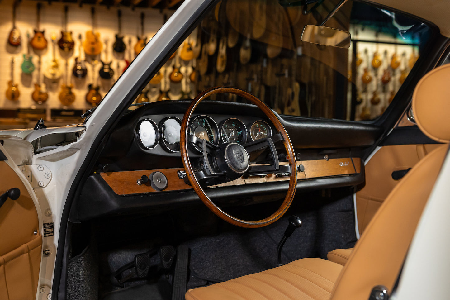 Car interior with wooden steering wheel and dashboard in a guitar store setting