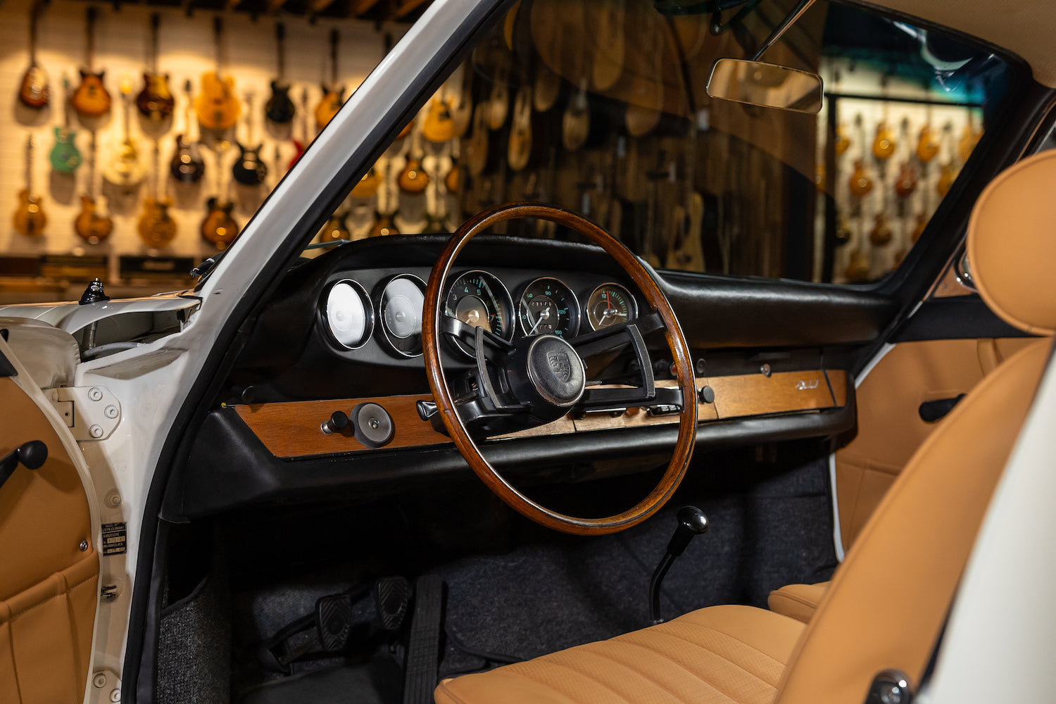 Car interior with wooden steering wheel and dashboard in a guitar store setting