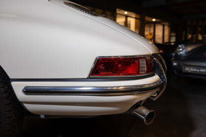 Close-up of a white car's rear end with a visible license plate.