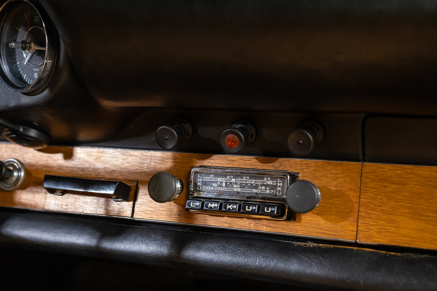Close-up of a vintage radio with wooden casing and control buttons.